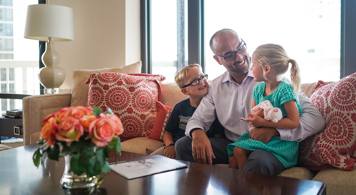 Andrew Ventura with his children happily sitting on the couch at home