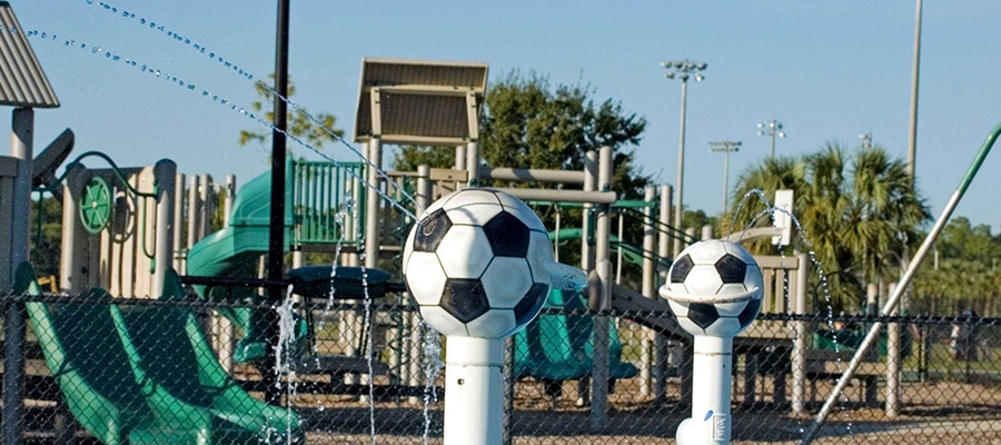 Soccer ball fountains in front of a colorful playground at the Vineyards Community Park Naples