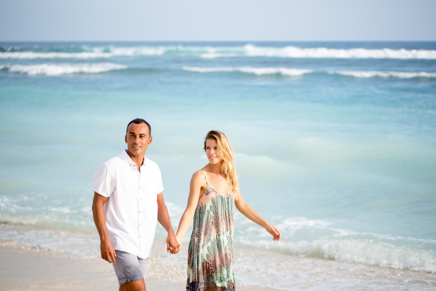 Content middle-aged real estate investment couple walking on beach